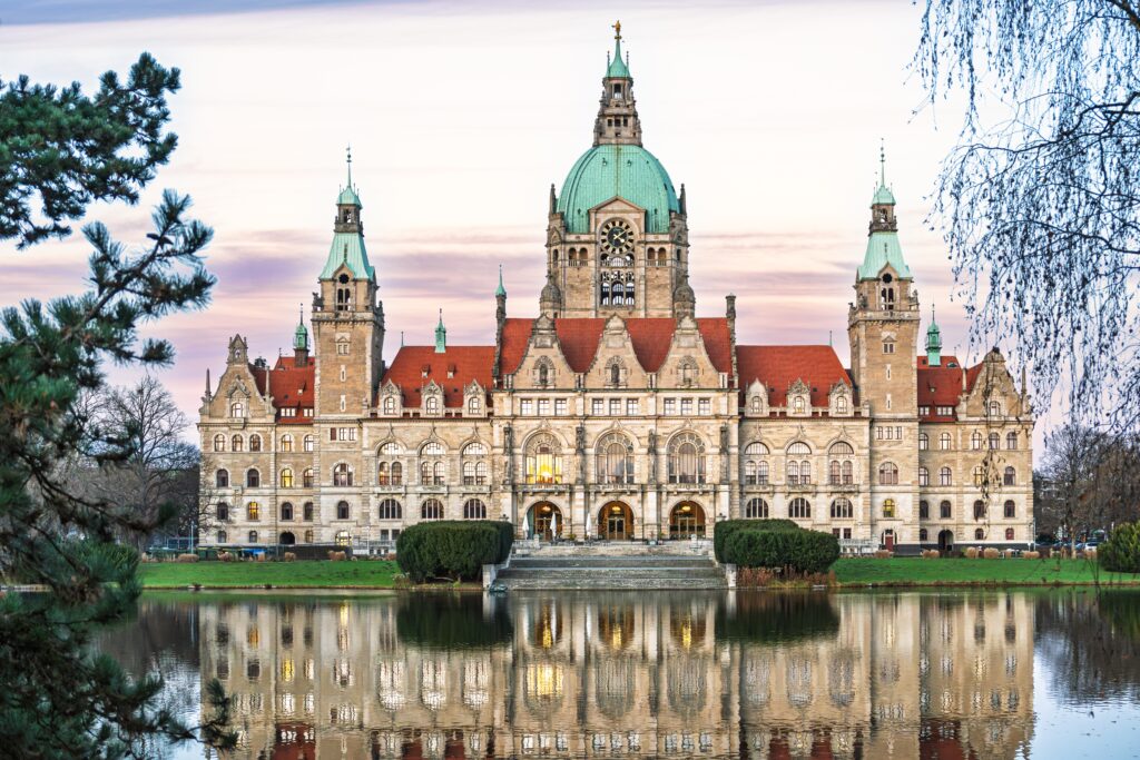 Das Neue Rathaus in Hannover bei Sonnenuntergang mit Spiegelung im Maschteich. Ihr professionelles Reinigungsunternehmen für Hannover, Celle und Winsen.