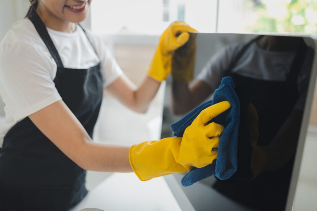 Reinigungsfachkraft bei der Bodenreinigung mit Wischmopp und Putzeimer. Professionelle Gebäudereinigung im Innenbereich.